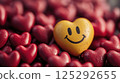 Cute yellow smiling smiley face in the shape of a heart among red hearts 125292655