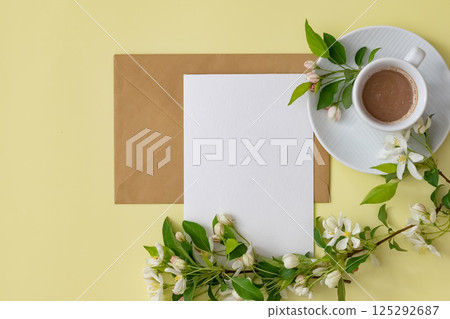 Workspace setup with coffee cup, notebook, pencil, and keyboard on wooden table 125292687