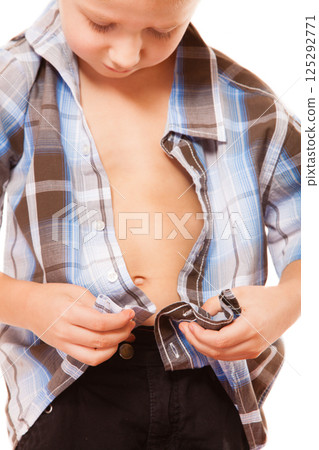 little boy buttoning on shirt, isolated on white little boy buttoning on shirt, isolated on white 125292771