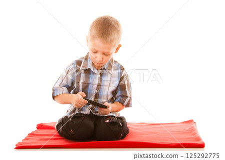 Little boy playing games on smartphone Little boy playing games on smartphone 125292775