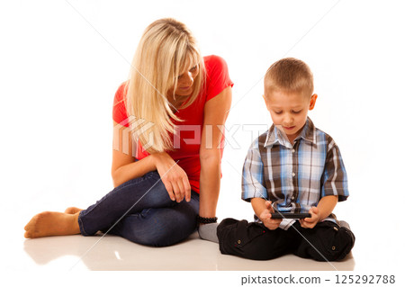 Mother and son playing video game on smartphone 125292788