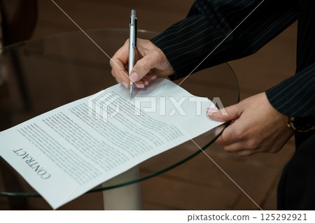 Signing a Formal Contract on a Glass Table 125292921