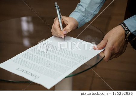 Signing a Contract on a Glass Table Signing a Contract on a Glass Table 125292926