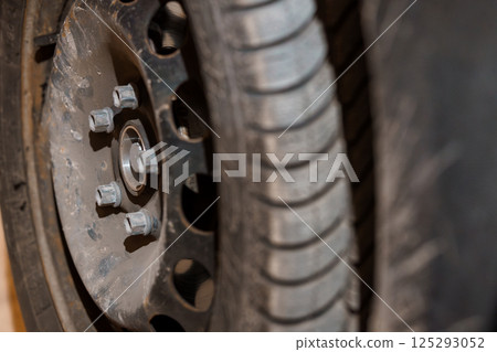Close-up of a Car Wheel and Tire with Focus on Lug Nuts 125293052