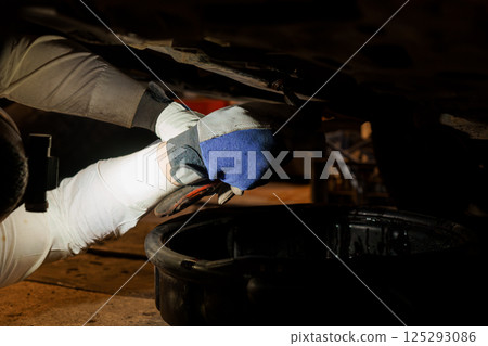 A Mechanic Working Under a Car to Perform Repairs 125293086