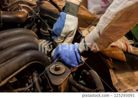 Mechanics Working on Car Engine with Gloves Mechanics Working on Car Engine with Gloves 125293091