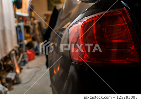 Rear View of a Car Tail Light in a Dimly Lit Garage Setting Rear View of a Car Tail Light in a Dimly Lit Garage Setting 125293093