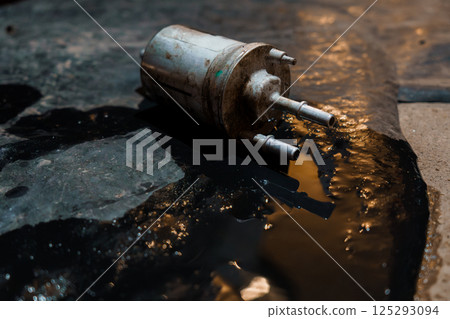 Abandoned Fuel Pump Surrounded by Oil and Grease on Concrete Floor 125293094