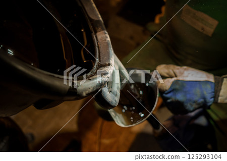 Industrial Worker Pouring Liquid from a Container into a Smaller Vessel Industrial Worker Pouring Liquid from a Container into a Smaller Vessel 125293104
