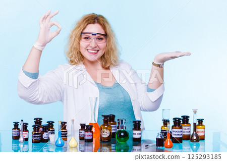 female chemistry student with test flask open palm 125293185