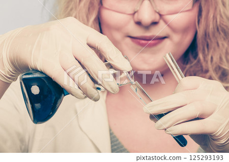 female chemistry student with glassware test flask. 125293193