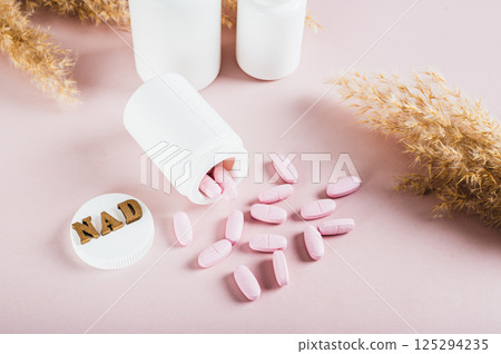 NAD+ molecule in pills for anti-aging and biohacking on pink background NAD+ molecule in pills for anti-aging and biohacking on pink background 125294235