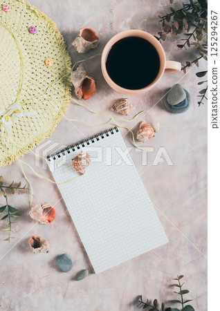 Notebook, beach hat, shells and stones on the table top and vertical view Notebook, beach hat, shells and stones on the table top and vertical view 125294267