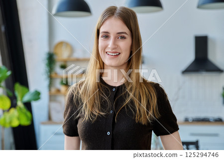 Portrait of beautiful young girl looking at camera, home interior background Portrait of beautiful young girl looking at camera, home interior background 125294746