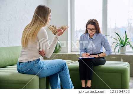 Professional female therapist counselor psychologist working with young woman patient Professional female therapist counselor psychologist working with young woman patient 125294793