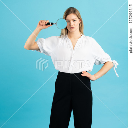 Studio portrait of woman with magnifying glass Studio portrait of woman with magnifying glass 125294845