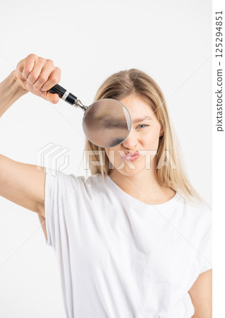 Studio portrait of woman with magnifying glass Studio portrait of woman with magnifying glass 125294851