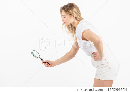 Studio portrait of woman with magnifying glass Studio portrait of woman with magnifying glass 125294854