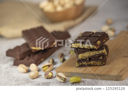 Delicious chocolate bar with pistachio pieces showcased in a Dubai setting, perfect for dessert Delicious chocolate bar with pistachio pieces showcased in a Dubai setting, perfect for dessert 125295120