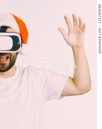 Man in virtual reality goggles and santa hat Man in virtual reality goggles and santa hat 125295696