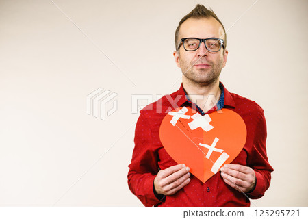 Adult man holding broken heart 125295721