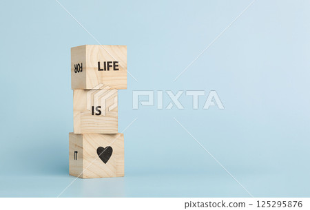 Wooden cubes with inscriptions Life Is Love on a blue background Wooden cubes with inscriptions Life Is Love on a blue background 125295876
