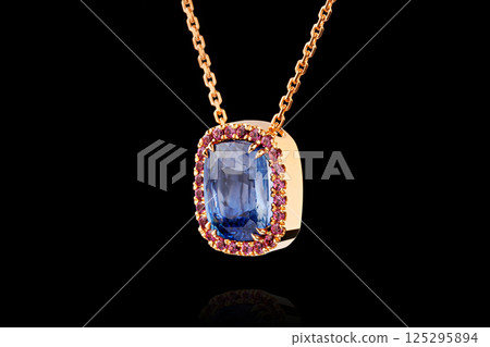 gold pendant with sapphire stone and diamonds on black background gold pendant with sapphire stone and diamonds on black background 125295894