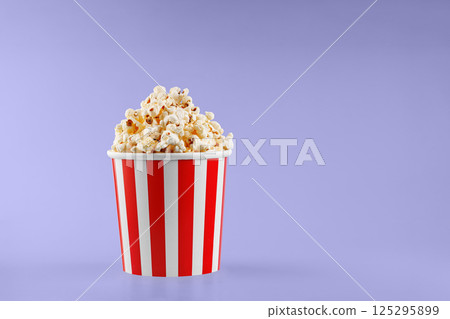 Classic red striped popcorn cardboard cup on Purple, violet background 125295899