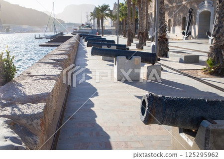 Historic coastal promenade with ancient cannons at sunset in Cartagena 125295962