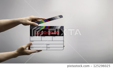 Digital film slate for filmmaker in set. Hand hitting timecode clapperboard or movie slate for Video Production. Digi number clapper board or film slates action on set. Tools in modern cinema industry 125296025