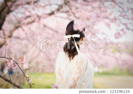 A woman standing under a cherry tree 125296120