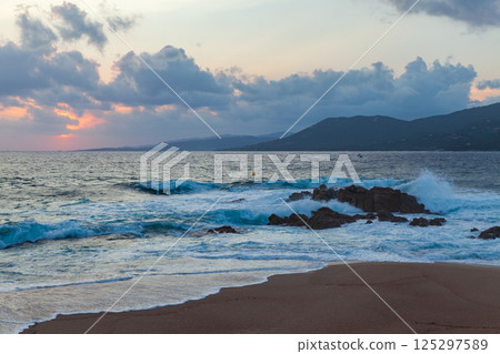 A picturesque shoreline with rocky formations, gently lapping waves. Corsica 125297589