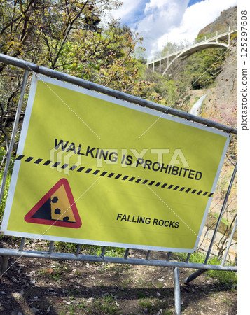 Restricted hiking trail in nature park due to rockfall risk, safety warning sign blocks access to protect visitors and preserve environment near scenic waterfall Restricted hiking trail in nature park due to rockfall risk, safety warning sign blocks access to protect visitors and preserve environment near scenic waterfall 125297608