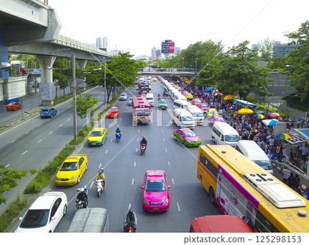 Traffic rush hour in Bangkok, Thailand, public transport, elevated railways and stations, food stalls lined up in the park, colorful umbrellas and people Traffic rush hour in Bangkok, Thailand, public transport, elevated railways and stations, food stalls lined up in the park, colorful umbrellas and people 125298153