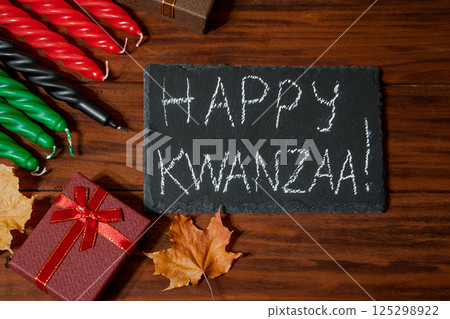 Kwanzaa African American holiday. Seven candles red, black and green on natural wooden background. 125298922