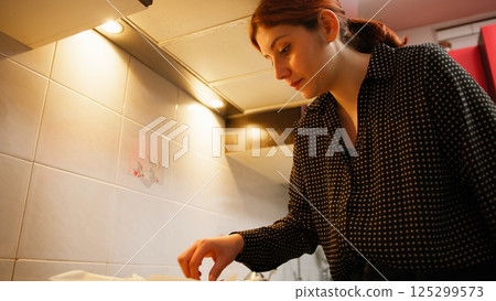 In the Kitchen of the House a Woman Turns the Biscuits for Double Baking In the Kitchen of the House a Woman Turns the Biscuits for Double Baking 125299573