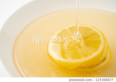Close-up of lemon drizzled in honey 125300877