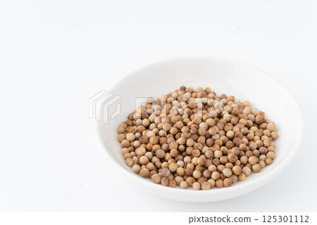 Whole coriander seeds on a plate 125301112