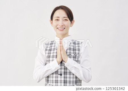 女職員祈禱，雙手合十，白色背景，看著相機 125301342