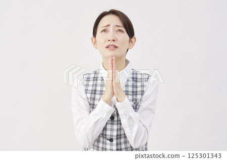 Female office worker begging, hands together in prayer, white background 125301343