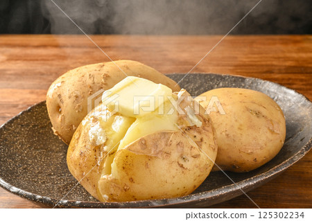 在蒸馬鈴薯上塗上奶油 在蒸馬鈴薯上塗上奶油 125302234