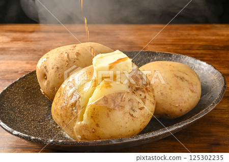 在馬鈴薯上塗上奶油和醬油。 在馬鈴薯上塗上奶油和醬油。 125302235