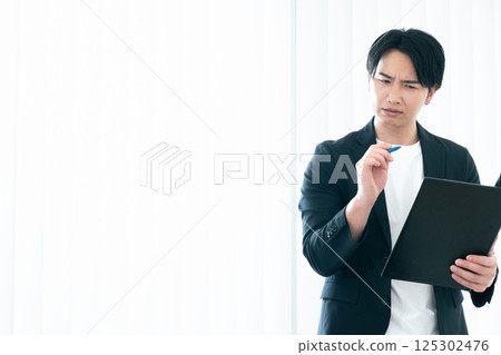 一位休閒風格的商人正在審查文件 125302476