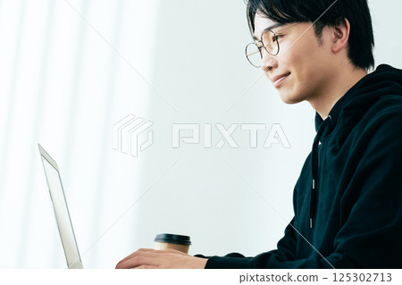 使用計算機的一個年輕人 125302713