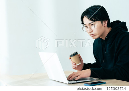 A young man using a computer 125302714