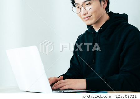使用計算機的一個年輕人 125302721