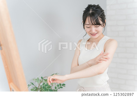 Asian woman applying body care, hair removal, moisturizing and sunscreen 125302897