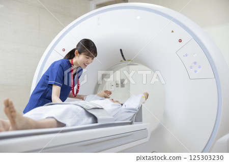 A man undergoing a CT scan with a radiologist. Photo courtesy of Denpa Gakuen, Tokyo Electronics College. 125303230