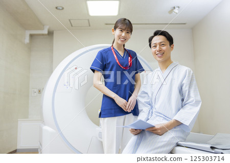 A man undergoing a CT scan with a radiologist. Photo courtesy of Denpa Gakuen, Tokyo Electronics College. 125303714