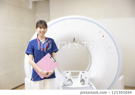 A radiologist standing in front of a CT scan. Photo courtesy of Denpa Gakuen, Tokyo Electronics College. 125303894